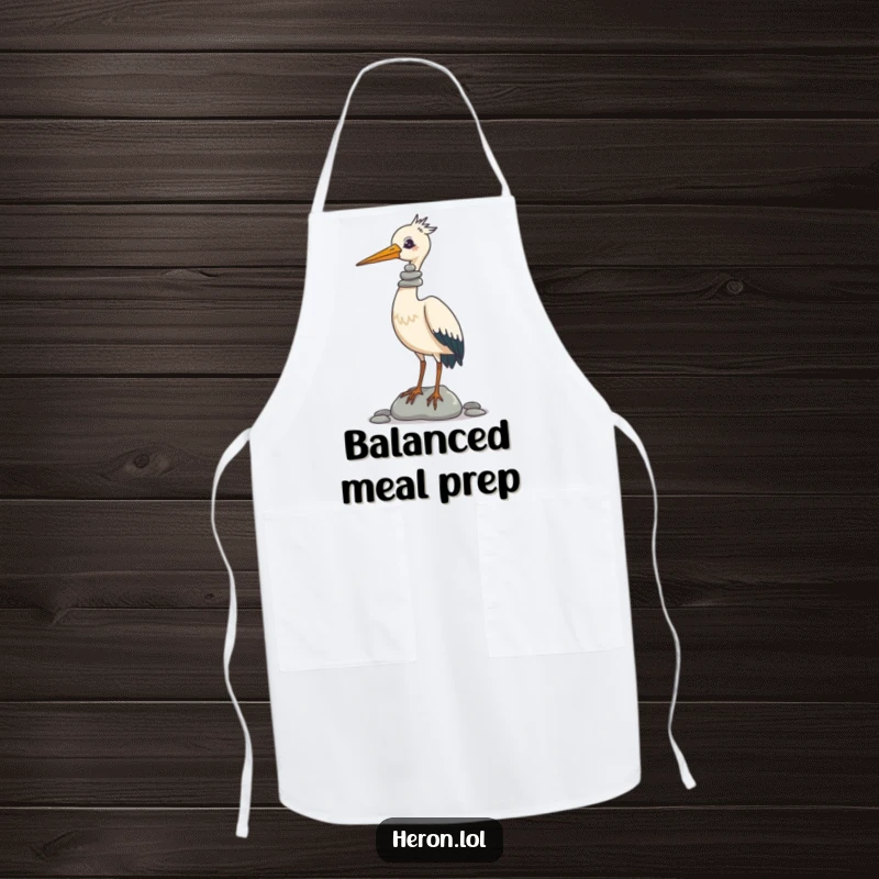 Funny Apron with a graphic of a heron expertly balancing a tower of pebbles on its beak, ideal for a chef with a sense of humor.